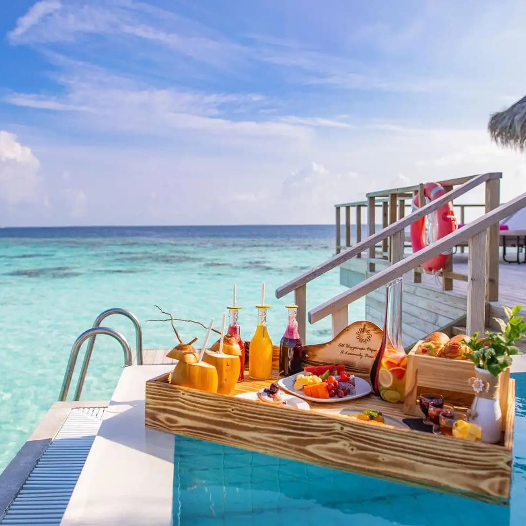 Water-villa breakfast arranged beside a turquoise Maldives lagoon