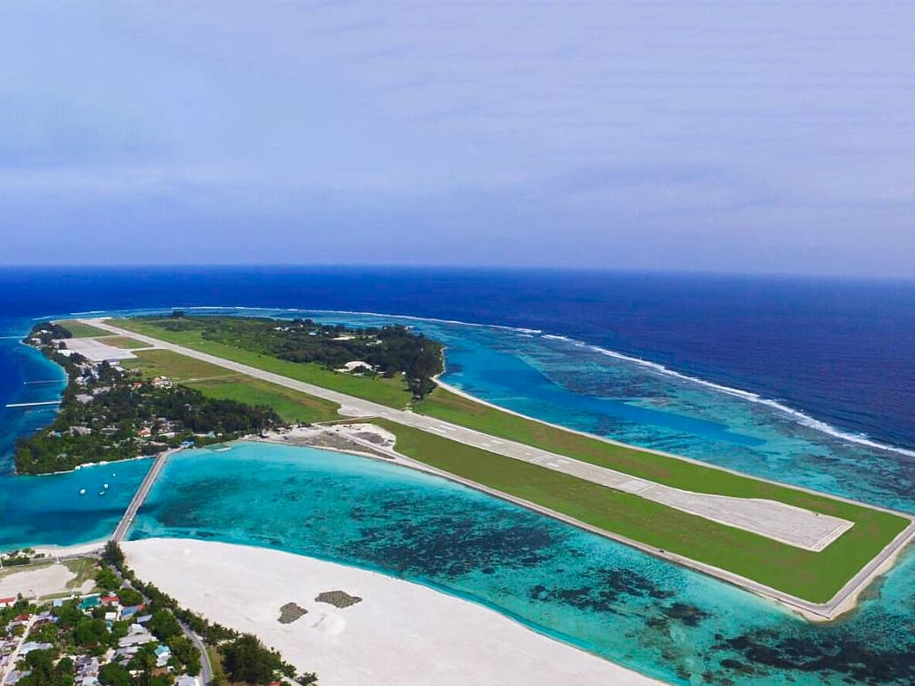 Gan International Airport runway surrounded by Addu Atoll's turquoise lagoon