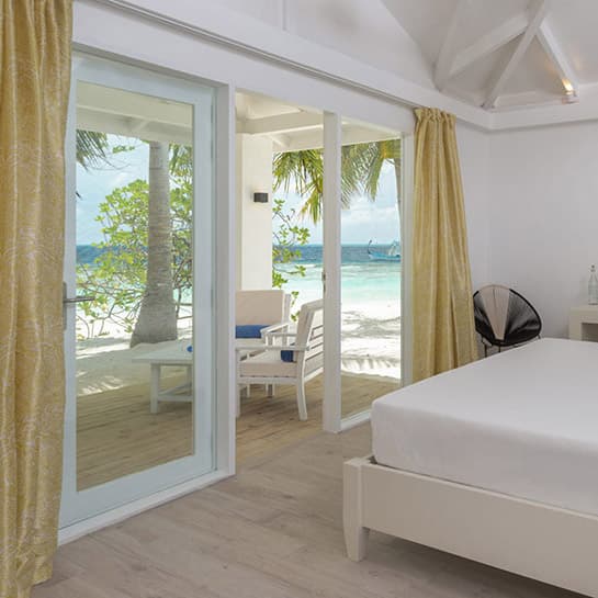 Bright beachfront room opening directly onto a Maldives beach