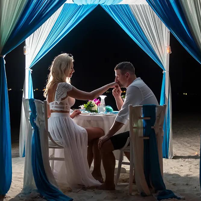 Couple enjoying a private candlelit beach dinner in the Maldives