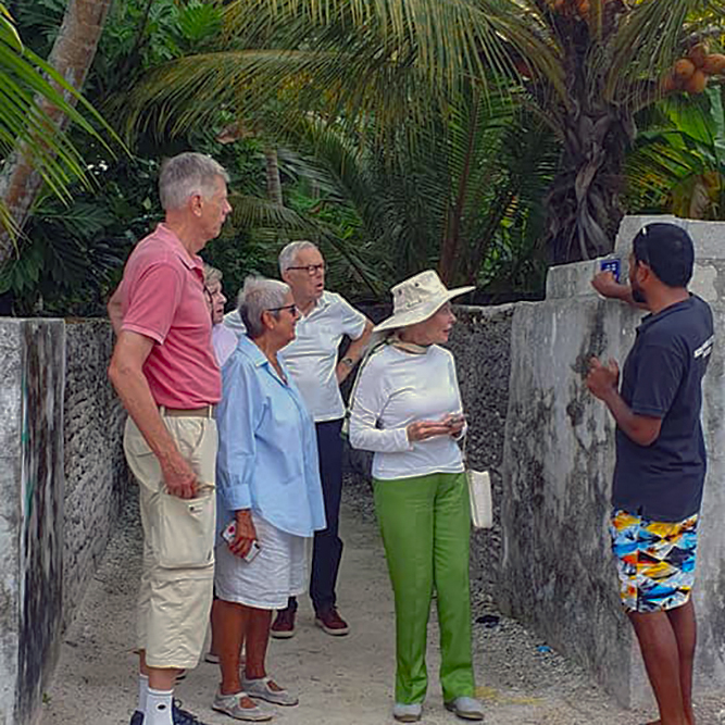 Tour guide explaining an old name boar of house in Meedhoo